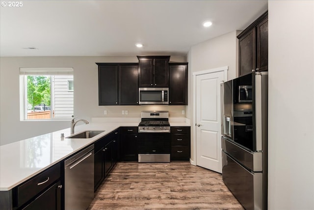 7119 NE 152nd Pl, Vancouver, WA 98682 - kitchen with appliances with stainless steel finishes, a sink, a peninsula, light wood finished floors, and light countertops