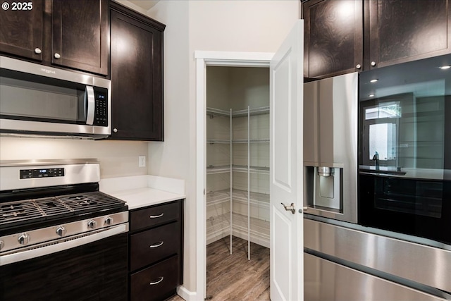 7119 NE 152nd Pl, Vancouver, WA 98682 - kitchen featuring stainless steel appliances, dark brown cabinetry, light countertops, and light wood finished floors