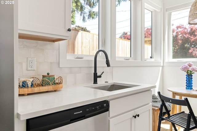 4633 SE 35th Ave Unit B, Portland, OR 97202 - kitchen featuring stainless steel dishwasher, a sink, backsplash, white cabinets, and light stone countertops