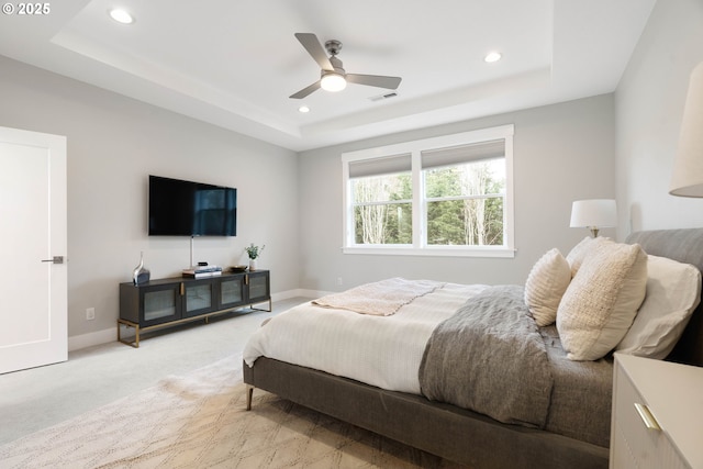 bedroom featuring visible vents, baseboards, light carpet, recessed lighting, and a raised ceiling