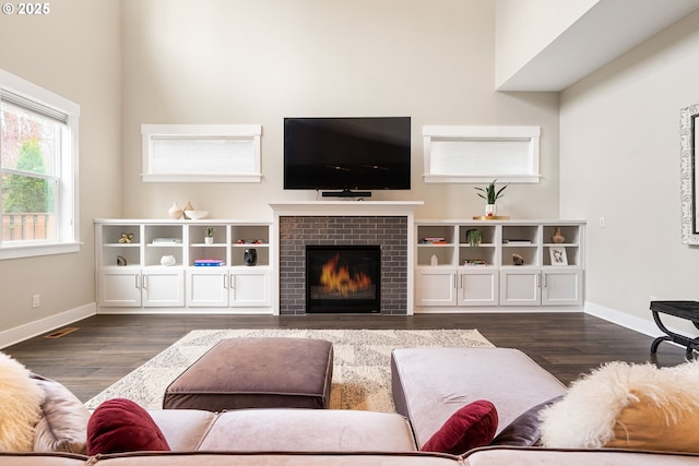 living area with baseboards, dark wood-style floors, and a fireplace