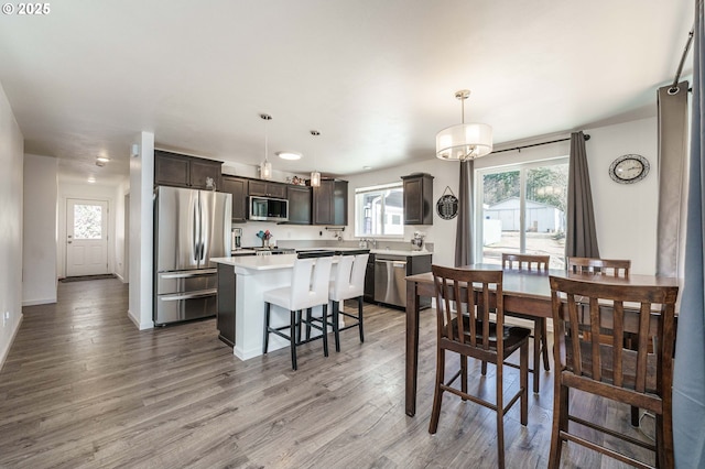 dining space with baseboards, an inviting chandelier, and light wood-style flooring