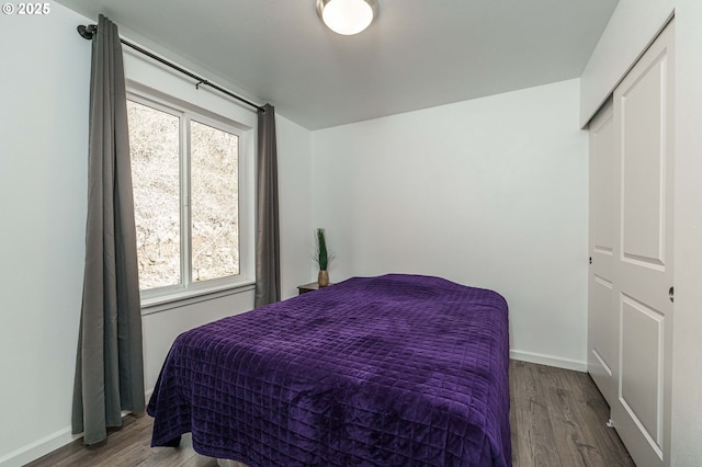 bedroom with baseboards and wood finished floors