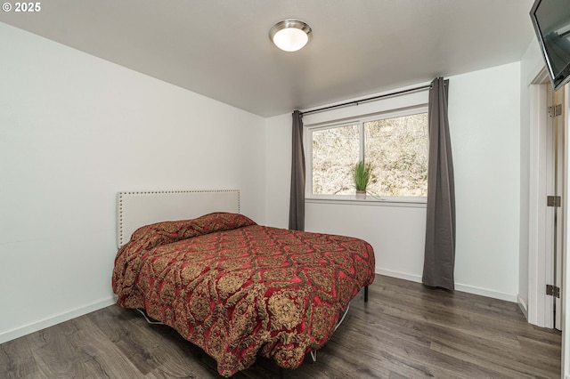 bedroom with wood finished floors and baseboards