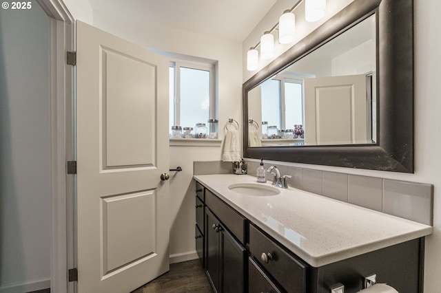 bathroom with vanity, wood finished floors, and tasteful backsplash