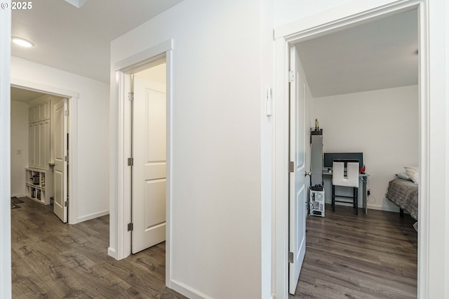 hallway featuring wood finished floors and baseboards