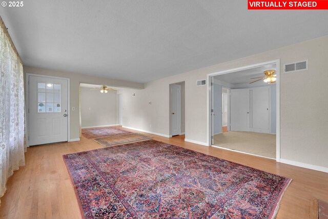 150 Maynard Ave, Eugene, OR 97404 - unfurnished living room featuring a ceiling fan, light wood-type flooring, and baseboards