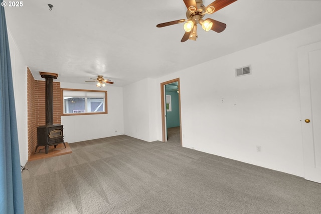 150 Maynard Ave, Eugene, OR 97404 - unfurnished living room with a wood stove, ceiling fan, and carpet
