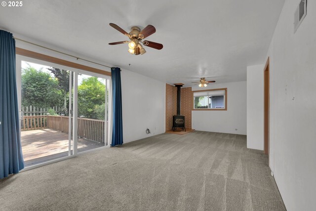 150 Maynard Ave, Eugene, OR 97404 - unfurnished living room featuring a wood stove, a ceiling fan, and carpet