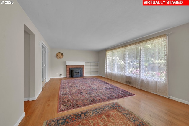 150 Maynard Ave, Eugene, OR 97404 - living room with wood finished floors, baseboards, and a brick fireplace