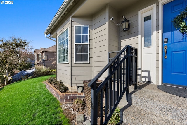 view of exterior entry featuring a lawn