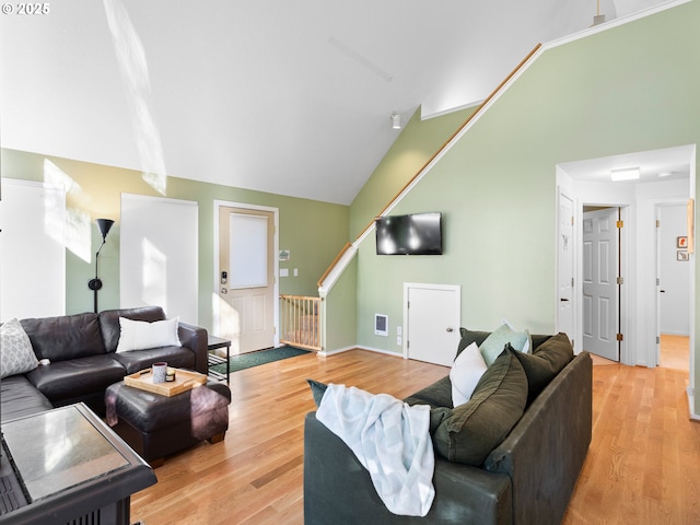 living room featuring lofted ceiling and light wood-type flooring