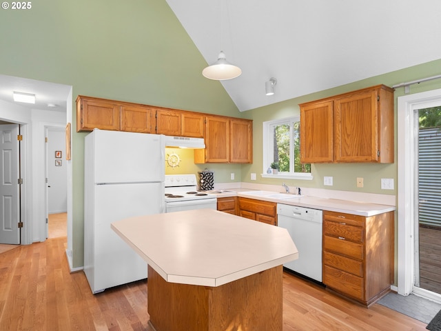 kitchen featuring sink, hanging light fixtures, light wood-type flooring, a kitchen island, and white appliances