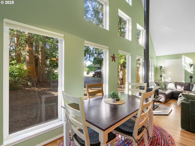 dining area with a high ceiling and light hardwood / wood-style flooring