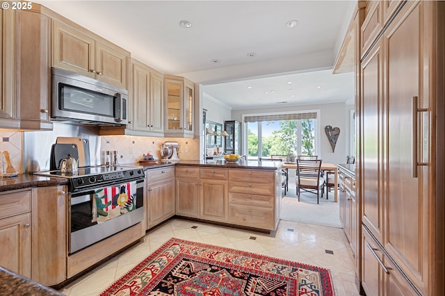 766 NW Westover Sq, Portland, OR 97210 - kitchen featuring stainless steel appliances, a peninsula, light tile patterned floors, crown molding, and recessed lighting