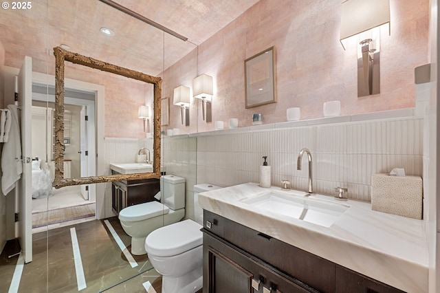 766 NW Westover Sq, Portland, OR 97210 - full bathroom with vanity, marble finish floors, tile walls, a bidet, and a wainscoted wall
