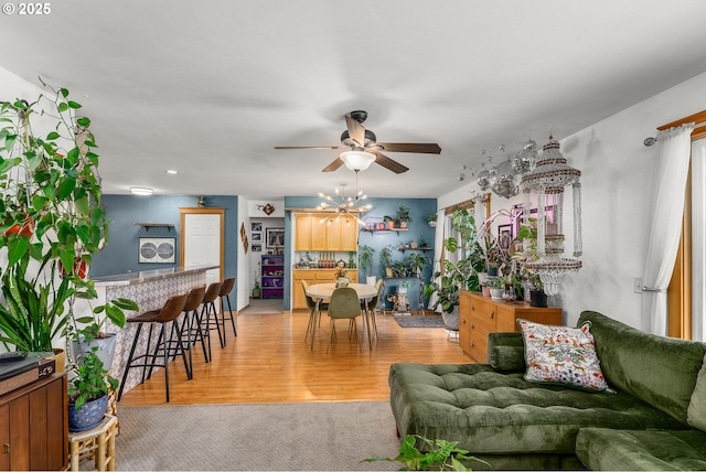 living room featuring light carpet, a ceiling fan, and light wood-style floors
