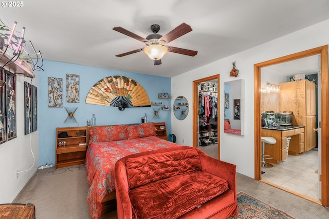 bedroom featuring a spacious closet, a ceiling fan, a closet, carpet floors, and connected bathroom