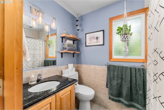 full bathroom with wainscoting, vanity, tile walls, toilet, and a shower with shower curtain
