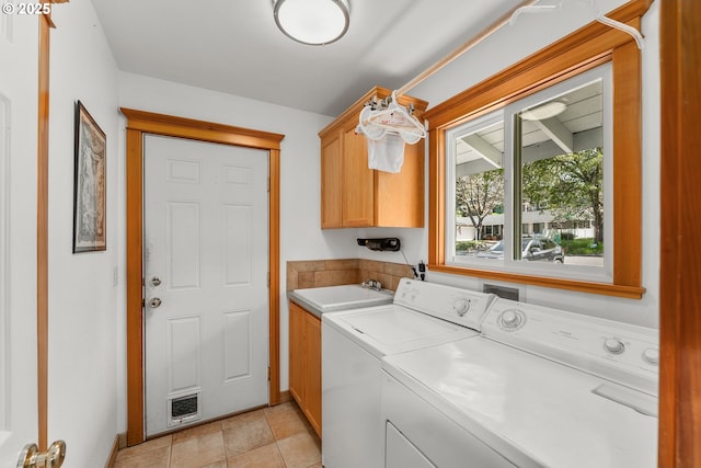 laundry room featuring baseboards, cabinet space, a sink, and independent washer and dryer