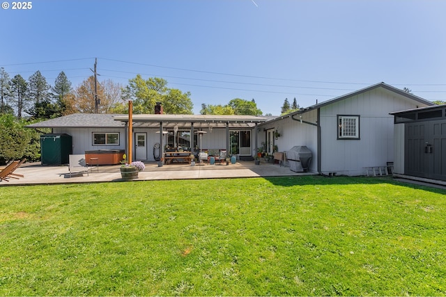 back of house with a yard, a hot tub, and a patio area