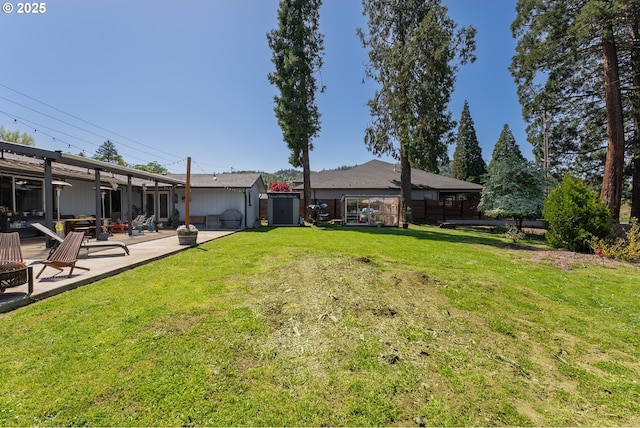 view of yard with a shed, an outdoor structure, fence, and a patio