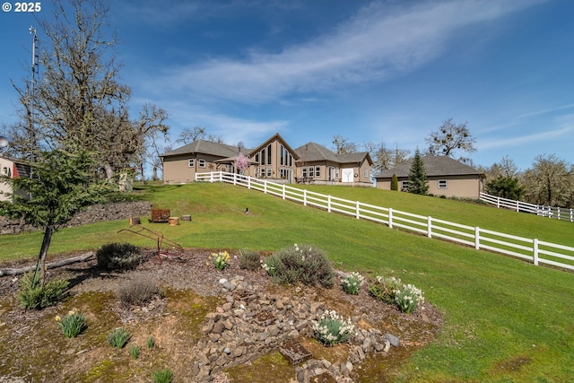 view of yard with fence and a rural view