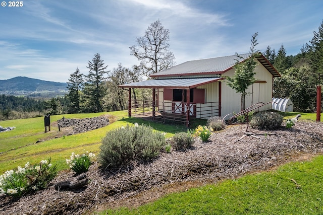 exterior space featuring an exterior structure, an outbuilding, a mountain view, and metal roof