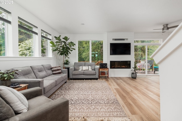 1937 NE 7th Dr, Lincoln City, OR 97367 - living room featuring healthy amount of natural light, wood finished floors, a large fireplace, and a ceiling fan