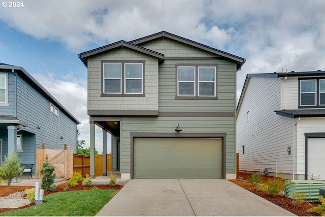 view of front of home with a garage and central AC