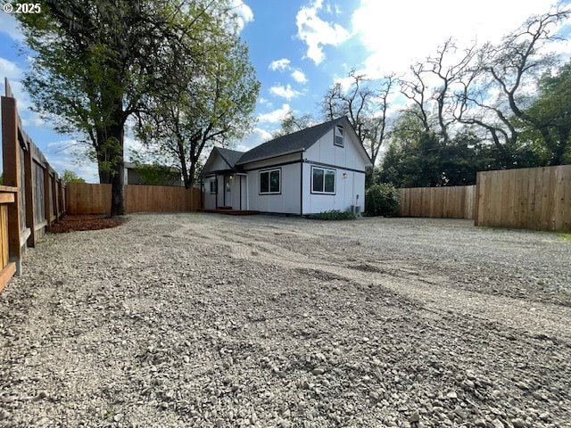view of home's exterior with a fenced backyard, board and batten siding, and driveway