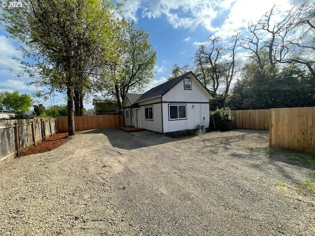 view of side of property with driveway and a fenced backyard