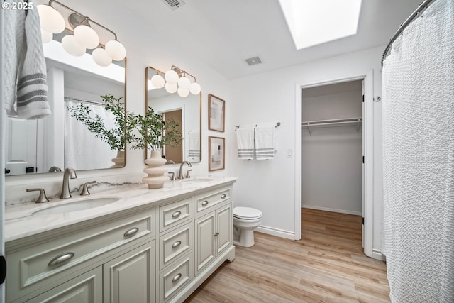 2952 NW Ogden St, Camas, WA 98607 - bathroom featuring double vanity, wood finished floors, toilet, baseboards, and a spacious closet
