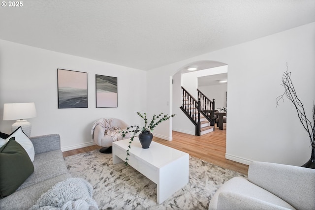 2952 NW Ogden St, Camas, WA 98607 - living room with arched walkways, stairway, wood finished floors, and baseboards