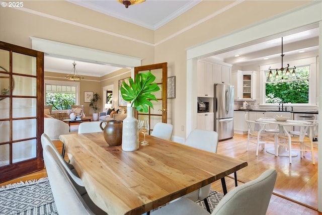 1520 SE 54th Ave, Portland, OR 97215 - dining room featuring a chandelier, light wood-type flooring, and crown molding