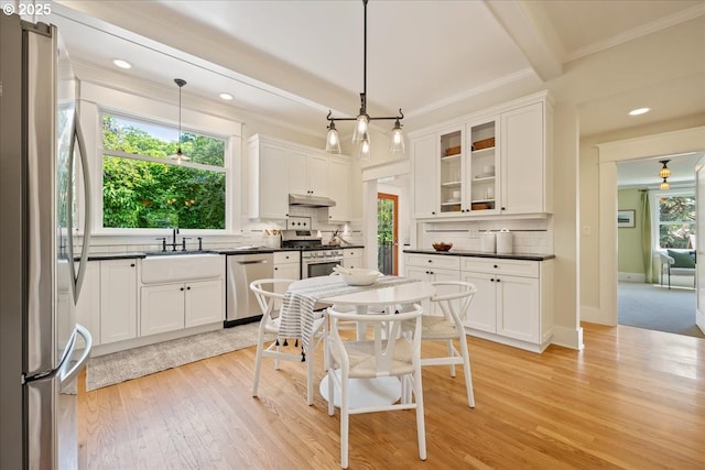 1520 SE 54th Ave, Portland, OR 97215 - kitchen featuring appliances with stainless steel finishes, dark countertops, white cabinetry, decorative backsplash, and crown molding