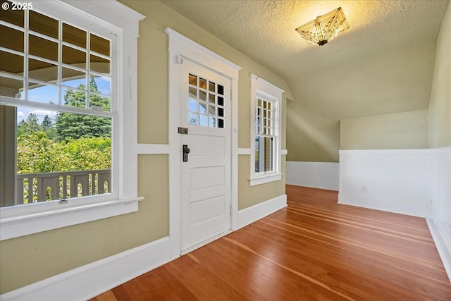 1520 SE 54th Ave, Portland, OR 97215 - foyer entrance featuring wood finished floors, lofted ceiling, plenty of natural light, a textured ceiling, and baseboards