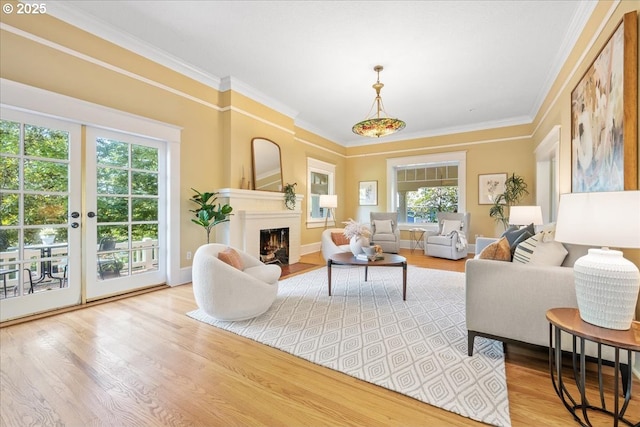 1520 SE 54th Ave, Portland, OR 97215 - living area featuring light wood finished floors, a warm lit fireplace, ornamental molding, and french doors