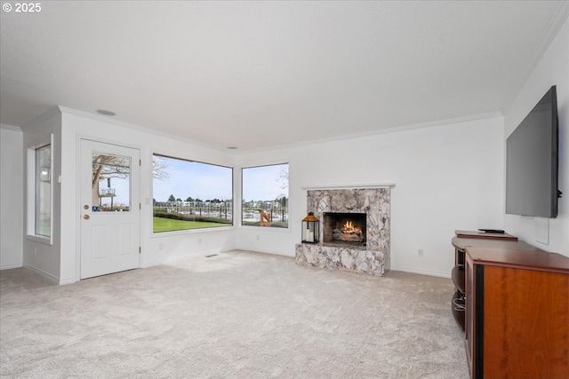 unfurnished living room featuring a fireplace, carpet floors, baseboards, and ornamental molding