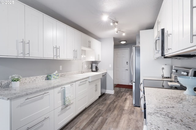 29460 SW Volley St Unit 72, Wilsonville, OR 97070 - kitchen featuring wood finished floors, a sink, baseboards, white cabinets, and stainless steel appliances