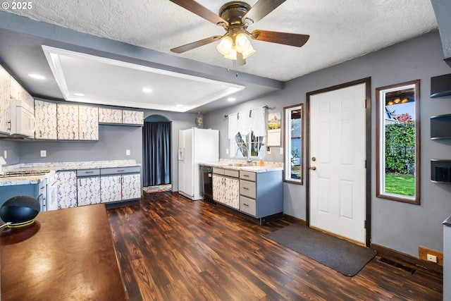 kitchen with baseboards, visible vents, white appliances, and dark wood-type flooring