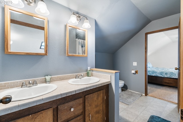 full bath with vaulted ceiling, toilet, double vanity, and a sink