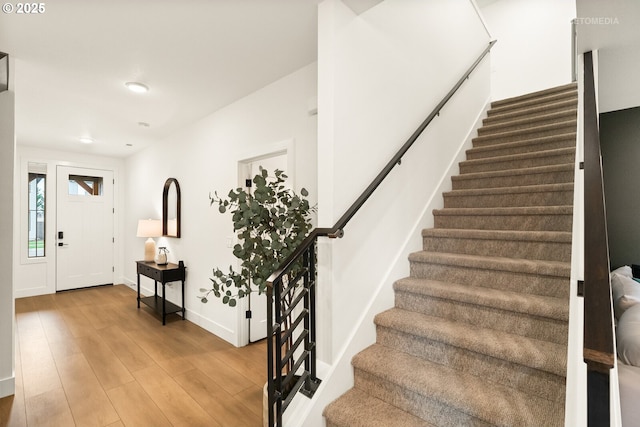 foyer entrance featuring light wood-style floors, baseboards, stairway, and recessed lighting