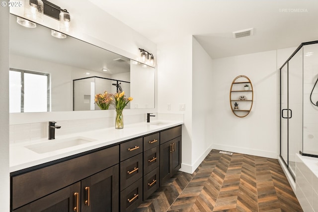 bathroom featuring a shower stall, double vanity, visible vents, and a sink