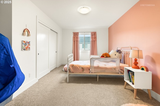 carpeted bedroom with baseboards and a closet