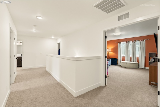 corridor featuring light carpet, an upstairs landing, visible vents, and baseboards