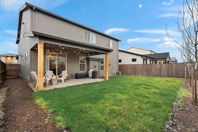 back of property with central AC unit, a yard, a patio area, and a fenced backyard