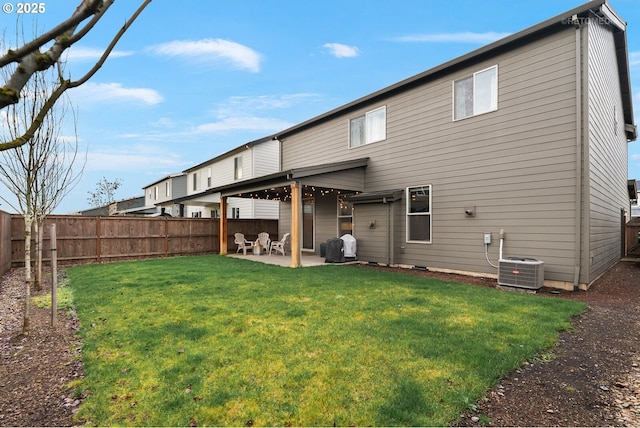 rear view of property with a yard, central AC unit, a patio area, and a fenced backyard