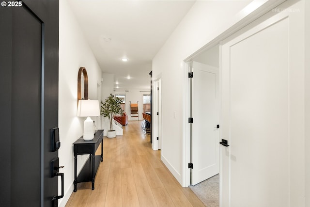 hallway with light wood finished floors and baseboards