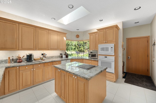 22750 SW Rosedale Rd, Beaverton, OR 97078 - kitchen with white appliances, a skylight, a kitchen island, light stone counters, and light tile patterned flooring